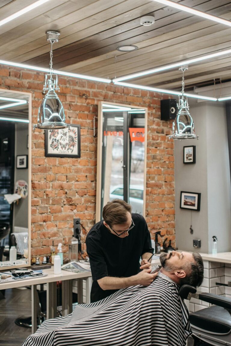 Barber expertly styling a client's beard in a modern barbershop setting.
