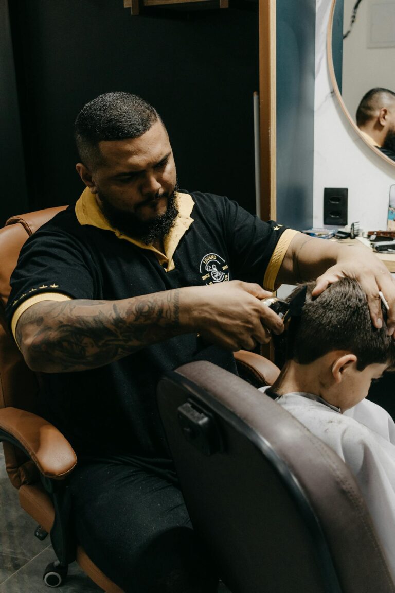 Barber skillfully cutting a young boy's hair in a modern barbershop setting.